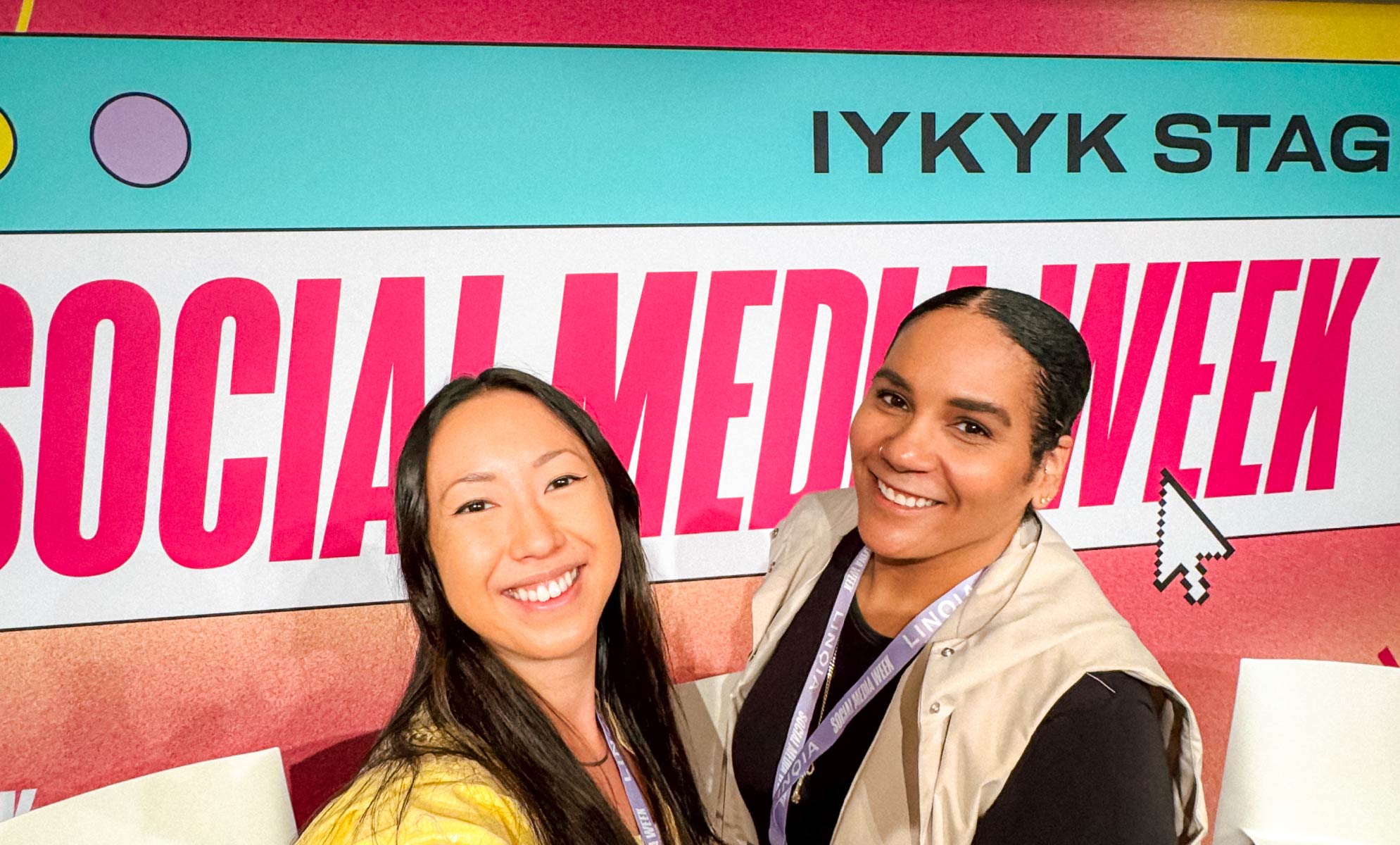 Selfie of two people in front of AdWeek Social Media Week sign.